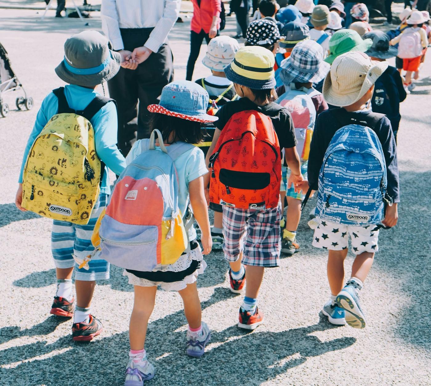 Children with backpacks walking into school