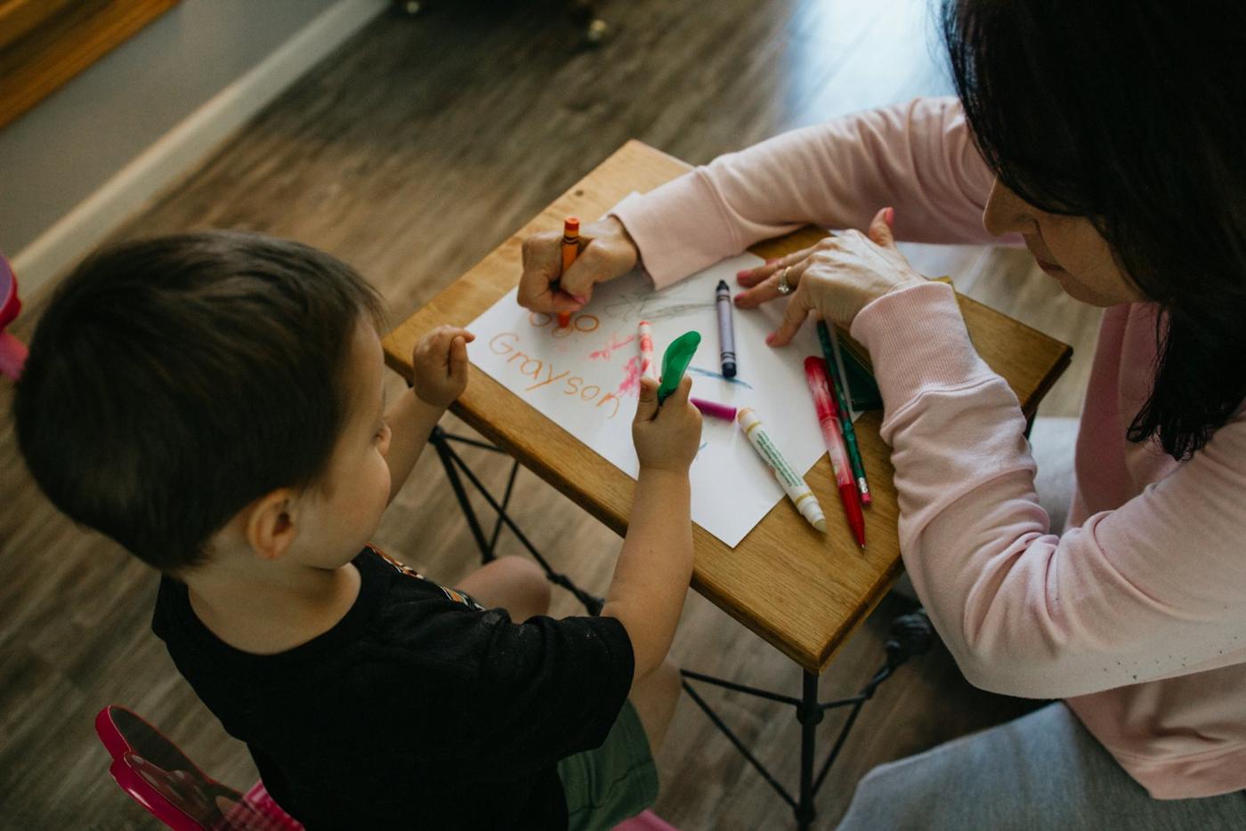 A guide and child color together